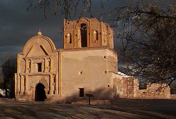Mission church with storm clouds overhead.